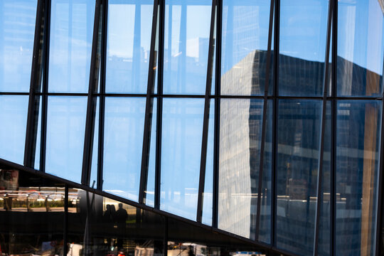 Modern corporate architecture seen through glass windows reflection with interior lines on an urban facade for workplace business background