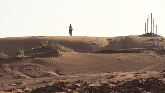 Solo Traveler Walking on Dubai Desert Sand Dunes at Sunrise Cinematic Travel Scene