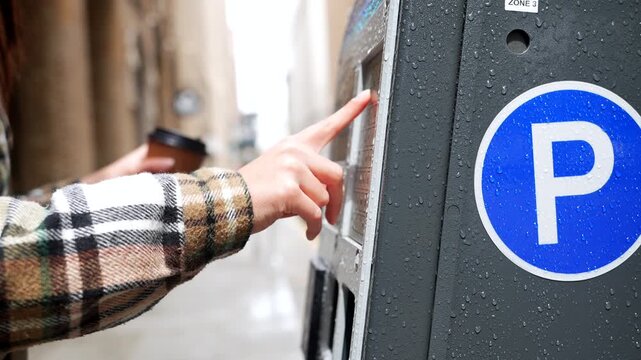 Woman paying for parking at an automated meter