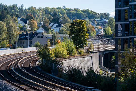 Neighborhood hillside above Brynseng shows metro curve and tracks on Oslo railway in Norway with transport corridor cutting through suburb