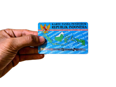Hand holding an Indonesian national identity card isolated on a white background.