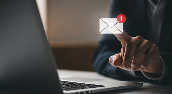 Closeup of a persons finger touching a digital icon representing a new email notification on a laptop screen