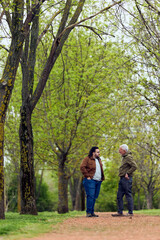 Fototapeta premium Two Men Talking on a Tree‑Lined Park Path in Spring — Conversation, Mentoring and Friendship