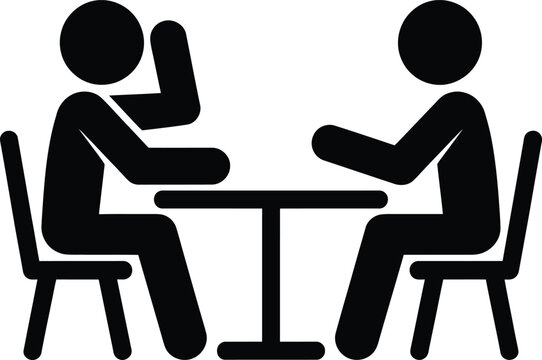 Two individuals engaged in a conversation across a small table