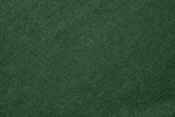 Fototapeta premium Green fabric background with a soft texture. The background is solid green, providing a smooth and consistent appearance. Simple green textured background with copy space.