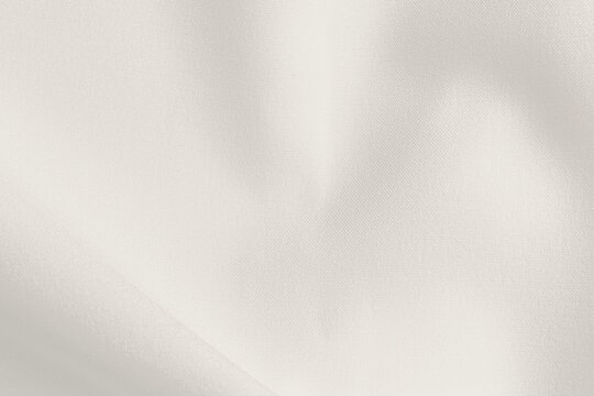 Smooth cream background with a soft, silky texture. The cream color enhances the elegant, minimalistic style of the background. Simple beige textured background with copy space.