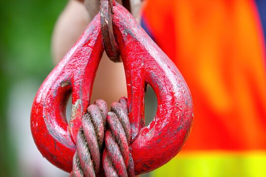 A close-up view of a red hook with a rope