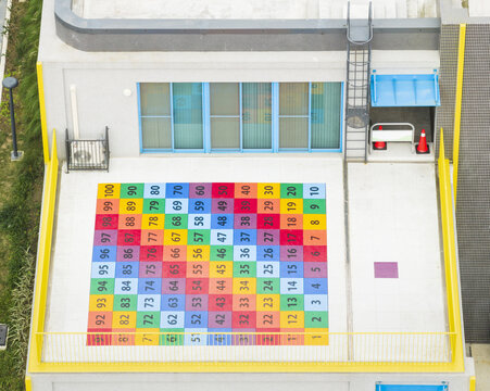 Aerial view of an elementary school rooftop featuring a large colorful grid of numbers from one to one hundred painted on the floor Taiwan.
