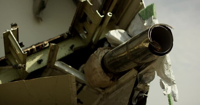 Detail shot of a cut metal pipe and structural wreckage from a disassembled aircraft in a scrapyard