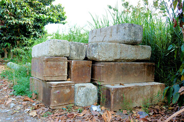 Stacked Concrete Blocks And Weathered Metal Forms In Overgrown Environment Representing Industrial Decay And Abandoned Construction Materials In Nature © ProArt Studios