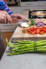 Cooking an italian frittata with mozarella, asparagus, eggs, onions, tomatoes and fresh herbs in spring time at home in the kitchen © mmphoto