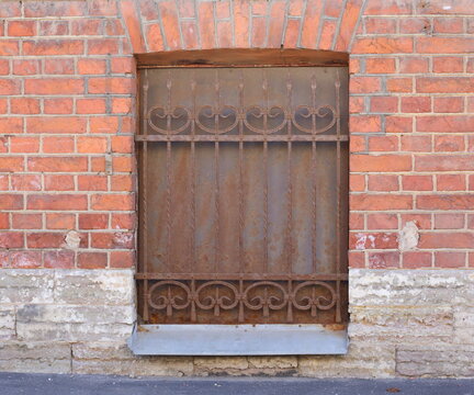 Muted basement window with a metal barrier