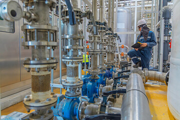 Male work inspection process valve control at the process area of the pipeline, flowing stainless steel chemicals in a factory © chitsanupong