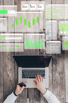 Digital business chart in use with laptop on wooden table showing financial data and analytics