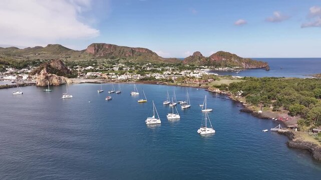 Drone flying in circular motion around coastline of Vulcano island with panoramic sea and landscape views.