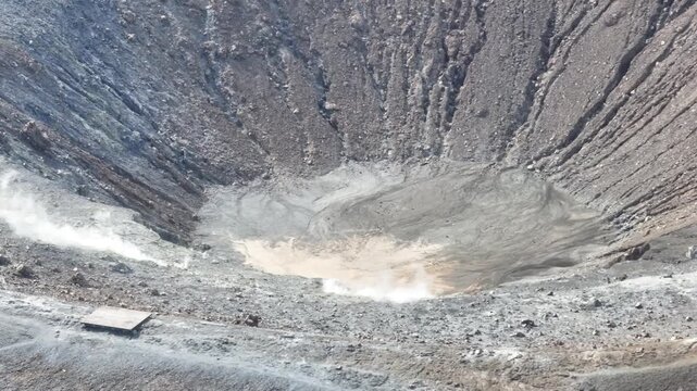 Close aerial shot moving around crater highlighting textures, smoke and volcanic formations.