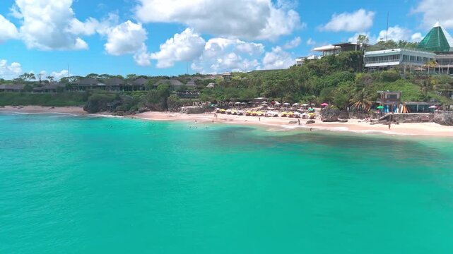 Crystal-clear water rolls onto the golden shoreline of Dreamland Beach as surfers and swimmers enjoy one of Bali&rsquo;s most scenic beaches.