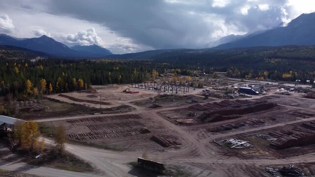 Metal frame construction site in lumber yard circling crane drone aerial wide