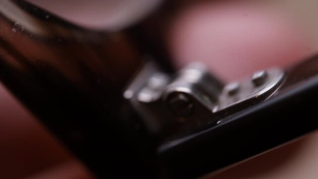 Extreme macro close-up of an old eyeglasses hinge being opened and closed by hand. Fine metal details, wear and movement clearly visible. Highly detailed and satisfying technical footage.