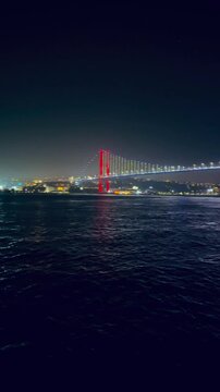 Serene Nighttime Scene Featuring Glowing Suspension Istanbul Bridge And Shimmering Reflections In Dark Bosfor Waters