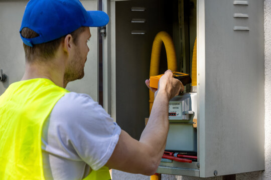 Technician checking natural gas leak with detector in meter box. Gas maintenance and repair service