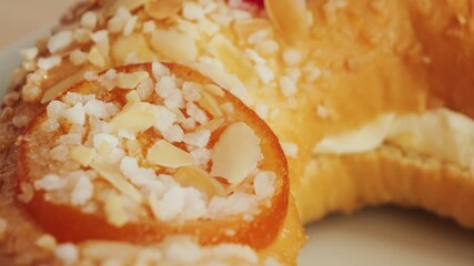 Roscon de reyes. A round pie baked from rich yeast dough and decorated with sugar, almonds and glazed fruits. High quality 4k footage