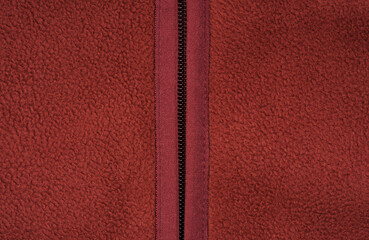 A zipper on clothing. The texture of fleece fabric and its inner or backing, background, or lining. Clothing, sewing. Faux fur. Background with a fur texture. © stas_malyarevsky