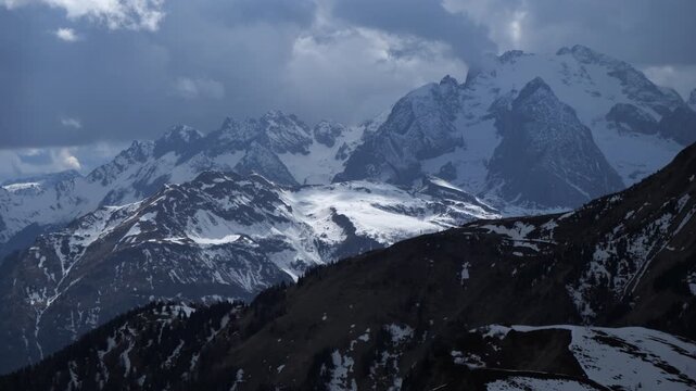 Time-lapse mountain landscape with snow and clouds moving