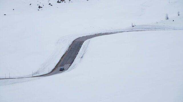 Car driving along a snow-covered mountain road with copy space