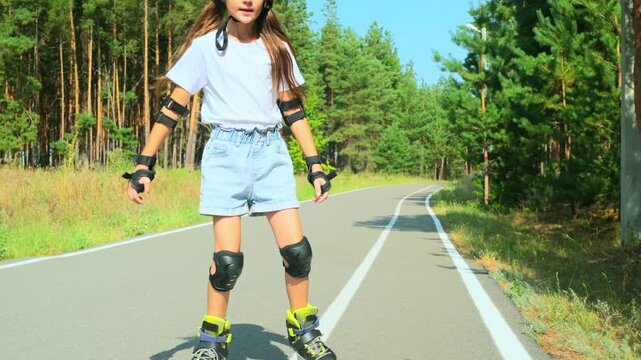 Girl is roller skating by forest, enjoying an active hobby in the open air.