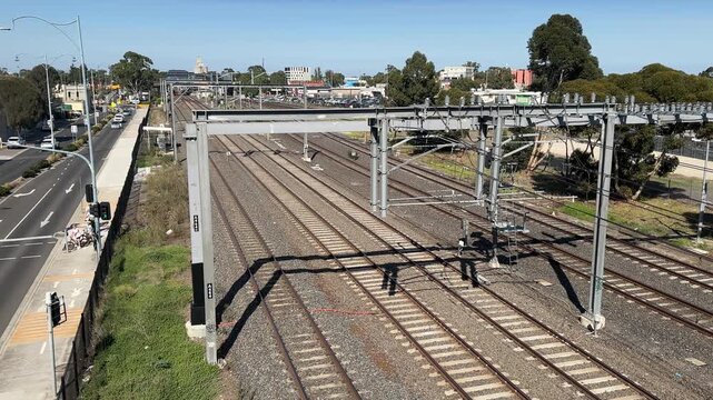 Aerial view of multiple parallel train tracks and overhead electrification infrastructure in the Melbourne suburb of Sunshine, Victoria, Australia.
