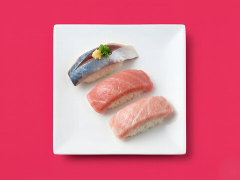 Assorted premium sushi set including mackerel chutoro and otoro on white plate with vibrant pink background