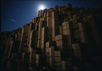 Fototapeta premium Basalt columns of Reynisfjara beach under a bright moon at night in Iceland