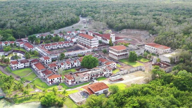 Drone aerial shot of the abandoned ghost hotel beside the Lagoon of Seven Colors in Bacalar, Mexico. Unique ruins surrounded by turquoise water, tropical nature, and iconic travel scenery.