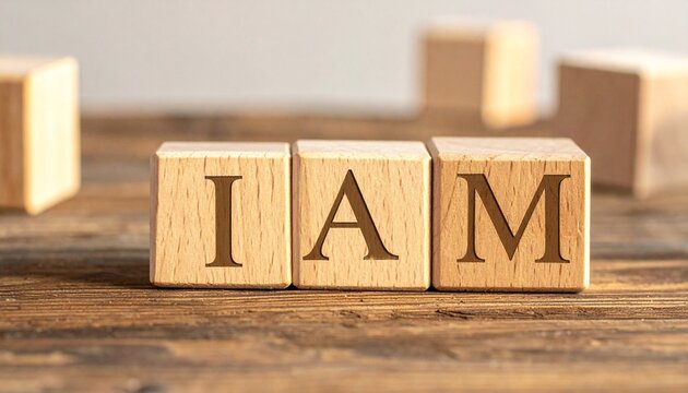 Three rustic wooden blocks engraved with letters forming &ldquo;I AM&rdquo; on warm textured surface, natural composition symbolizing identity, affirmation, motivation, and self-reflection in a timeless, groundin