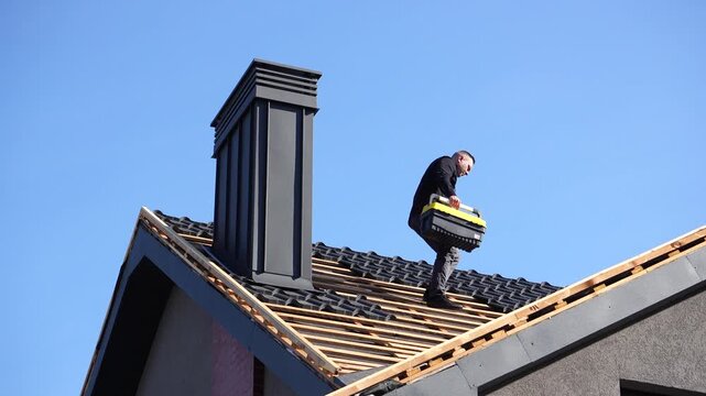Roof work. A man on a roof with tools prepares for work and repairs. Roof work on a private home.