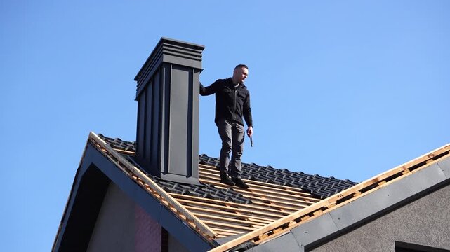 Roof work. A man on a roof with tools prepares for work and repairs. Roof work on a private home.