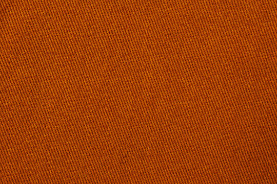 Warm orange denim fabric texture with diagonal twill weave vibrant textile background