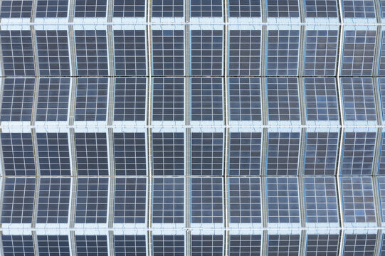 Aerial view of solar panels on the factory roof arranged in a precise grid pattern on an industrial building in Taiwan.