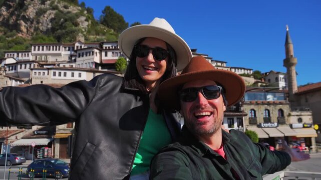 Portrait Joyful heterosexual couple looking at camera taking selfie photo laughing enjoying spring vacation get away holidays.Berat, Albania. Concept connection, happiness, freedom, fun, bonding