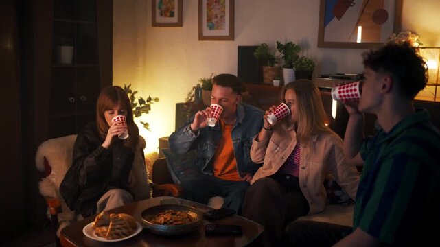 Young friends toasting with drinks at home gathering