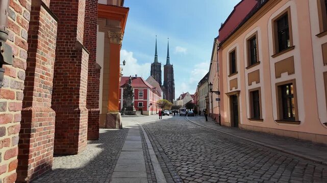 Scenic street view of Ostr&oacute;w Tumski in Wrocław, Poland, with cathedral towers. Perfect video clip of a leisurely walk through historic cobblestone streets, travel and tourism footage.