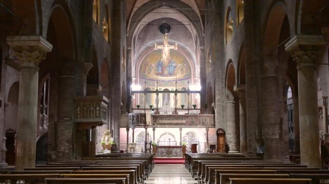Modena, italy, april 11, 2026. Majestic view of the romanesque cathedral interior in modena, italy, showing the nave, columns, arches, and altar with a crucifix mosaic
