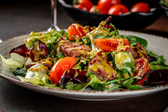 Close up fresh salad with grilled meat and dressing