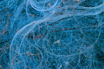 Obraz premium Close-up of tangled blue fishing net background. Abstract mesh texture of nylon threads.