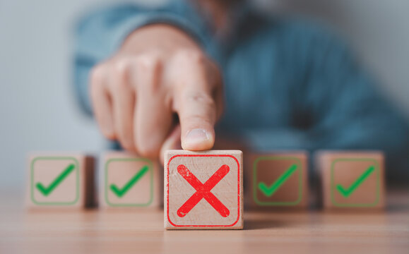 Rejection and selection concept with hand choosing wrong option marked with red cross among correct choices, symbol decision making, evaluation process, risk management and business quality control