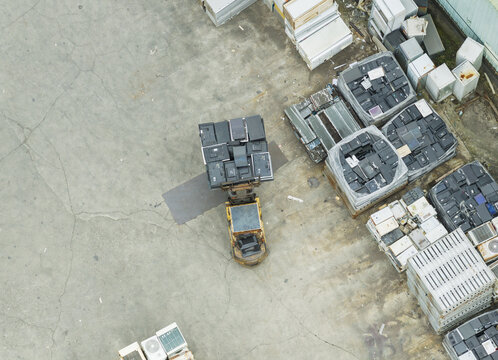 Aerial view of a home appliance recycling plant with a forklift moving old televisions and stacks of refrigerators and air conditioners in Taiwan.