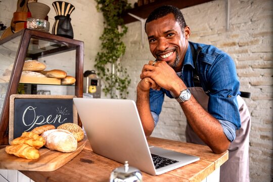 Smiling baker using laptop photo