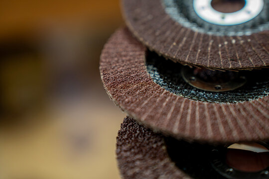 Macro close-up of layered flap abrasive discs, showing rough sanding material and circular metal center for grinding or surface finishing.