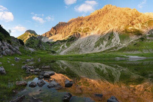 Mountains shine in the evening sun, Glasfelderkopf in the middle, Fuchskarspitze on the right, reflection in the mountain lake at the Prinz-Luitpolt-House, sunset, Bad Hindelang, Allg&auml;u, Bavaria, Germany
